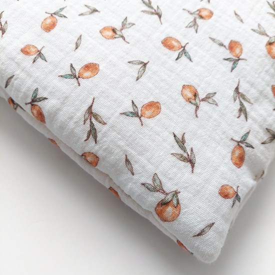 otulacz muślinowy w kolorze zgaszonej zieleni i poduszka w cytrynki