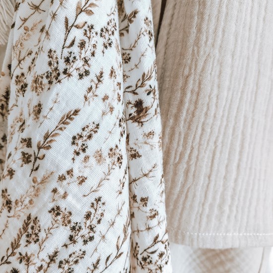 pieluszka muślinowa w kolorze bieli w suche trawy