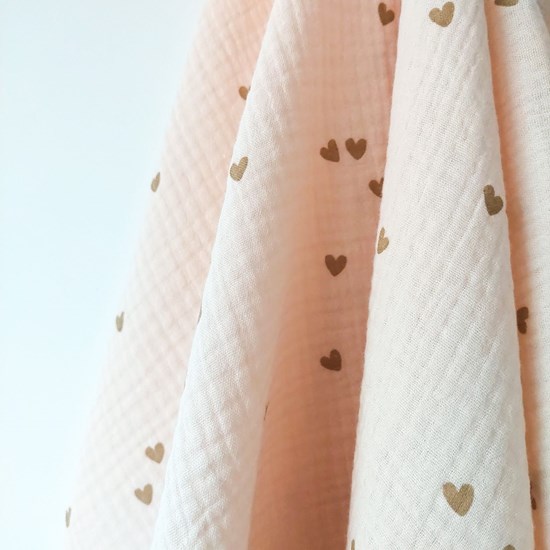 otulacz z bawełny muślinowej w kolorze różu w serduszka z czterema mini chwostami w kolorze beżu