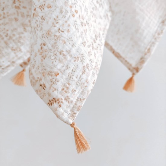 otulacz z bawełny muślinowej w kolorze bieli w kwiatuszki z czterema mini chwostami w kolorze beżu