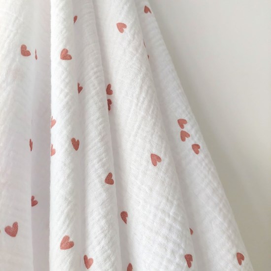 otulacz z bawełny muślinowej w kolorze bieli w serduszka z czterema mini chwostami w kolorze różu