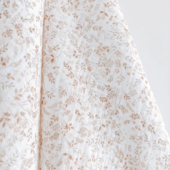 otulacz z bawełny muślinowej w kolorze bieli w kwiatuszki z czterema mini chwostami w kolorze beżu