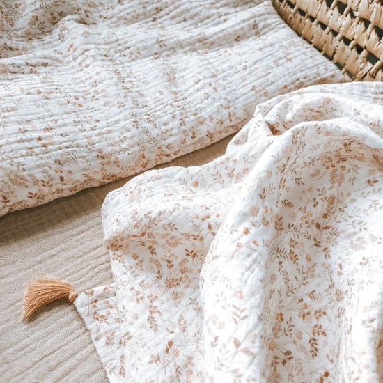 otulacz z bawełny muślinowej w kolorze bieli w kwiatuszki z czterema mini chwostami w kolorze beżu