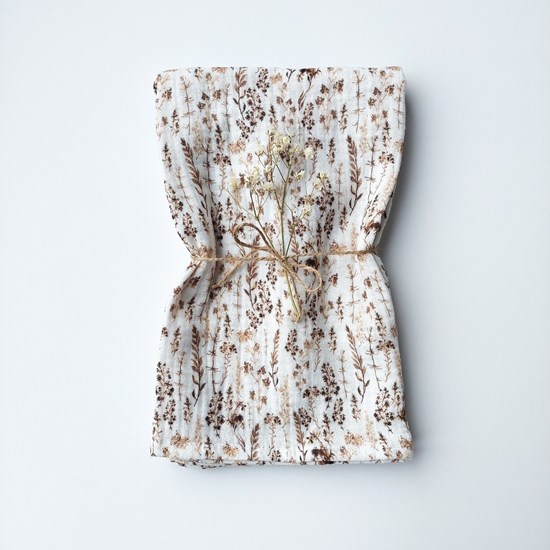 pieluszka muślinowa w kolorze bieli w suche trawy