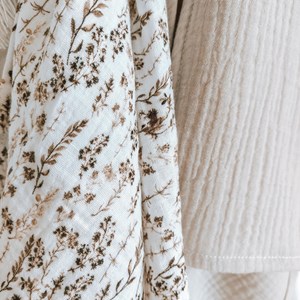 pieluszka muślinowa w kolorze bieli w suche trawy