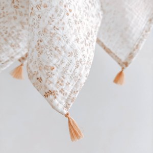 otulacz z bawełny muślinowej w kolorze bieli w kwiatuszki z czterema mini chwostami w kolorze beżu