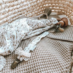 pieluszka muślinowa w kolorze bieli w suche trawy